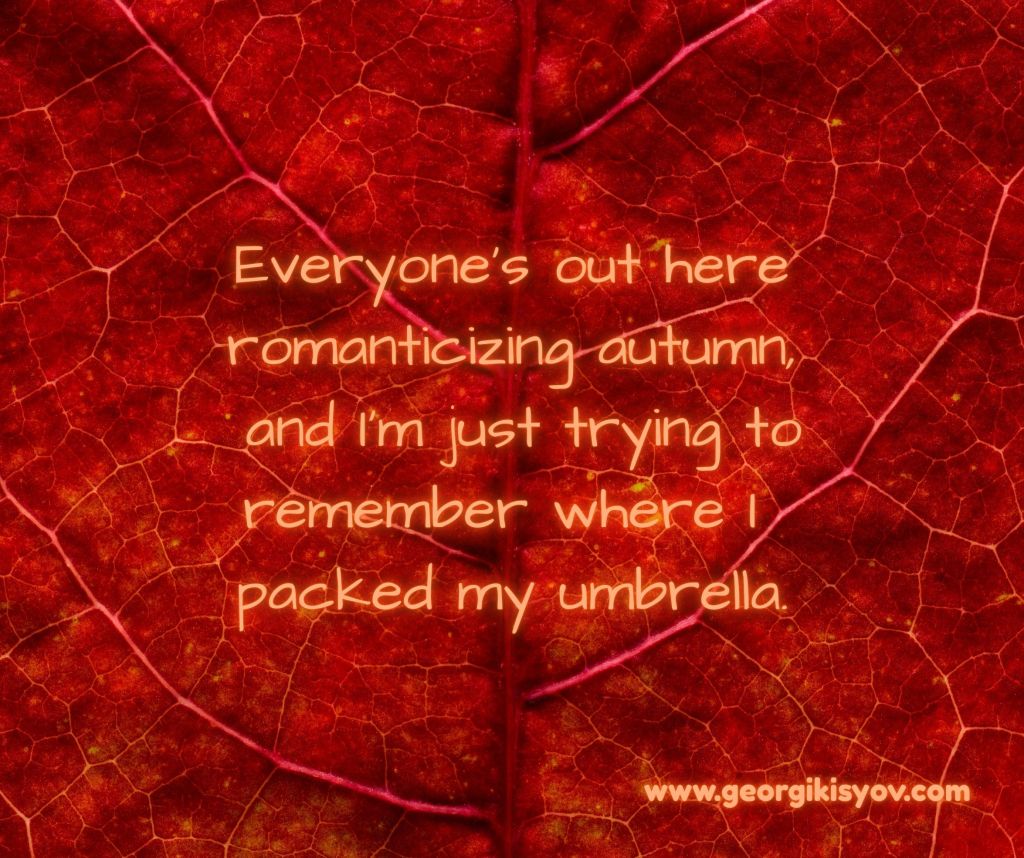 Autumn leaf background with a funny quote about romanticizing autumn and forgetting umbrellas.
